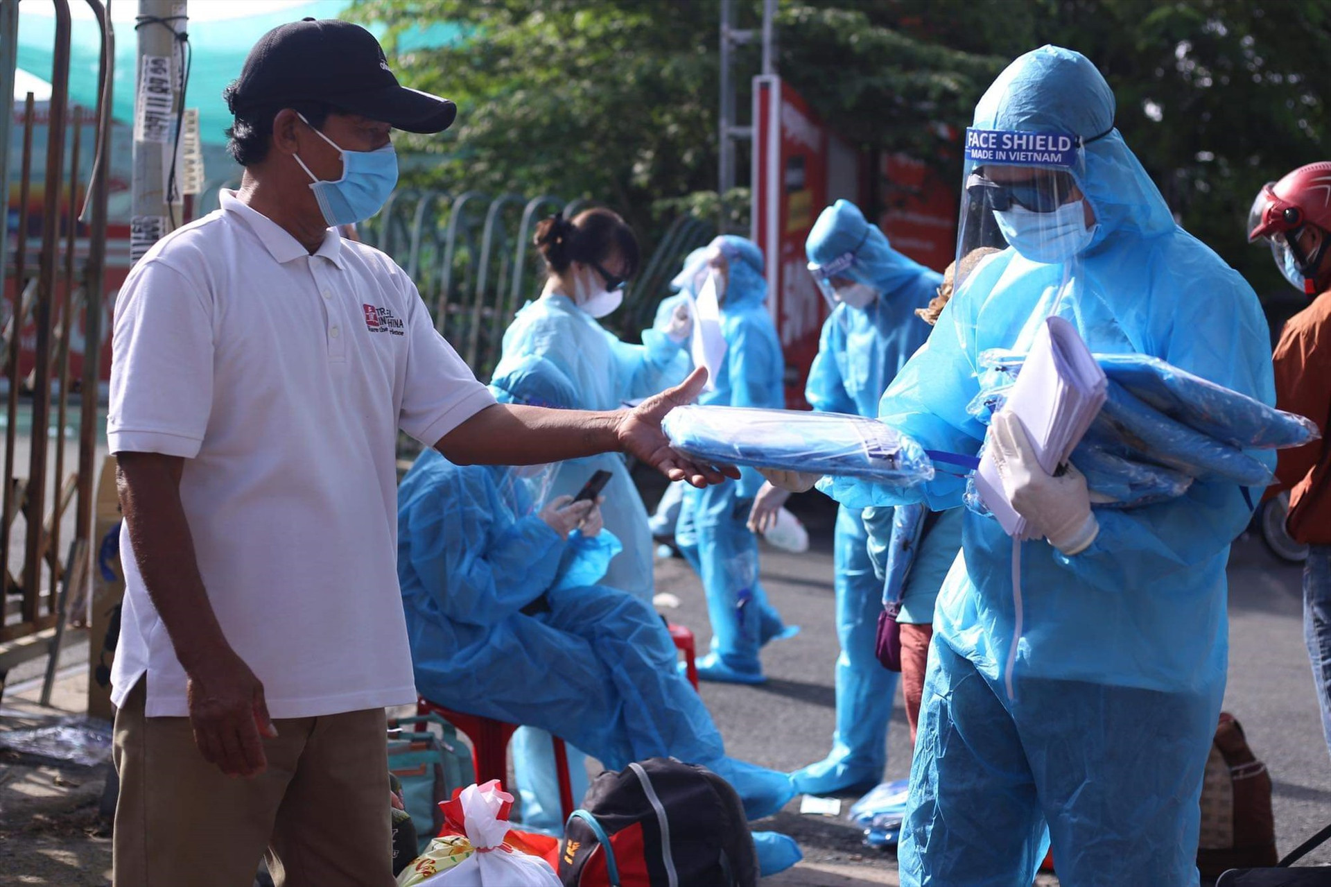 Đoàn công tác Thăng Bình phát đồ bảo hộ cho người dân trước khi lên xe.