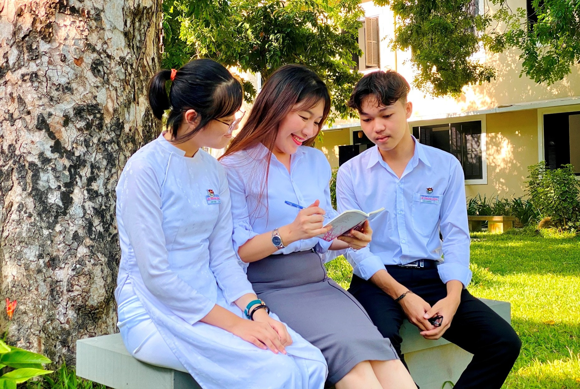 Thí sinh duy nhất của Quảng Nam đoạt điểm 10 môn Văn trong kỳ thi tốt nghiệp THPT năm 2021 - Đặng Văn Quang (phải) cùng cô giáo chủ nhiệm và bạn học. Ảnh: CH.NỮ
