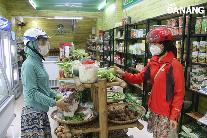 Người dân mua hàng tại cửa hàng Thu Bồn mart. Ảnh: VĂN HOÀNG
