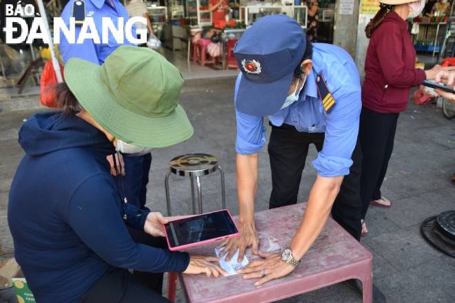 Người dân chỉ được giải quyết vào chợ khi dùng thẻ QR-code và đi đùng ngày. QUỲNH TRANG.