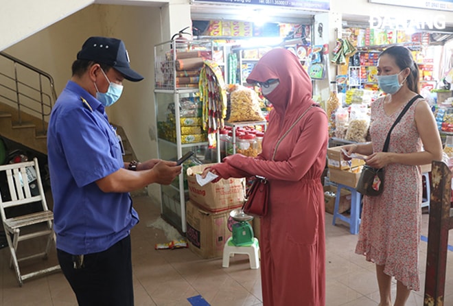 Lực lượng thuộc Ban quản lý chợ Đống Đa quét mã QR code trên thẻ đi chợ của người dân. Ảnh: VĂN HOÀNG