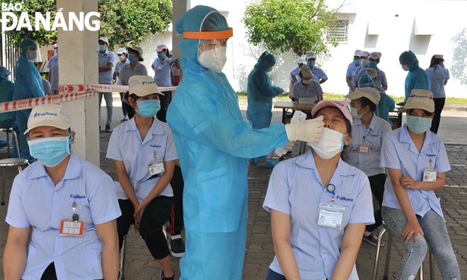 Công nhân Khu Công nghiệp Hòa Cầm được lấy mẫu xét nghiệm SARS-CoV-2 tại nơi làm việc. Ảnh: TRIỆU TÙNG