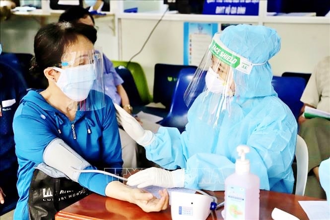 Lực lượng y tế khám sàng lọc trước khi tiêm vaccine phòng COVID-19 trong đợt 5 cho người trên 65 tuổi, người mắc bệnh mãn tính, người thuộc diện chính sách, người có công. Ảnh: Hồng Giang/TTXVN