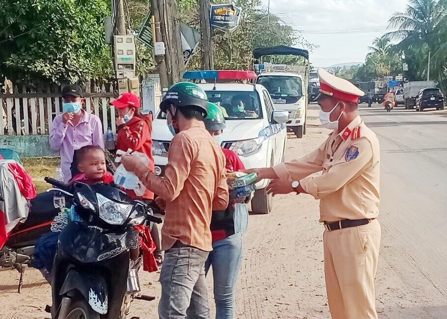 Lực lượng chức năng tỉnh hướng dẫn, hỗ trợ người dân về từ vùng dịch bằng xe máy đoạn qua địa bàn huyện Phước Sơn. Ảnh: CTV