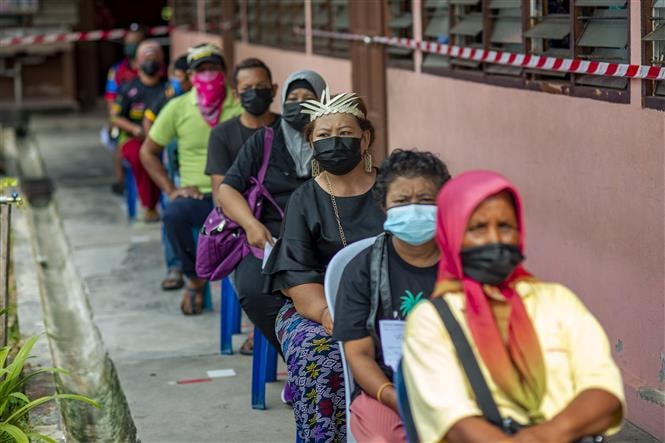 Người dân xếp hàng chờ tiêm vaccine ngừa COVID-19 tại Selangor , Malaysia, ngày 25/7/2021. ảnh: THX/TTXVN