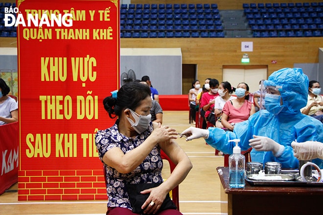 Mỗi đơn vị phụ trách tiêm chủng cố định bố trí từ 5-6 bàn tiêm, mỗi bàn tiêm khoảng 200 người/ngày. Ảnh: XUÂN DŨNG