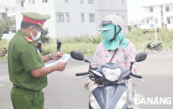 Công an quận Sơn Trà kiểm tra giấy đi đường của người dân phường Nại Hiên Đông.Ảnh: ĐẮC MẠNH