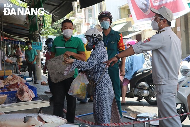 Lực lượng Quy tắc đô thị phường Thuận Phước, quận Hải Châu kiểm tra các quầy hàng buôn bán bên ngoài chợ Đống Đa. Ảnh: VĂN HOÀNG