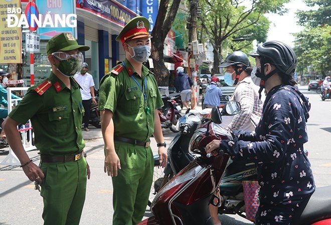 Các lực lượng rất vất vả trong việc nhắc nhở người dân giữ khoảng cách an toàn khi mua sắm trong sáng 12-8. Ảnh: VĂN HOÀNG.