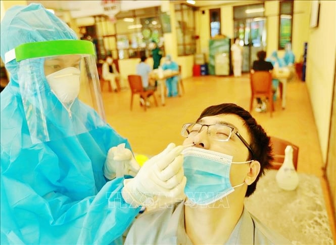 Lấy mẫu xét nghiệm Covid-19 cho người dân ở khu vực có nguy cơ cao. Ảnh: TTXVN