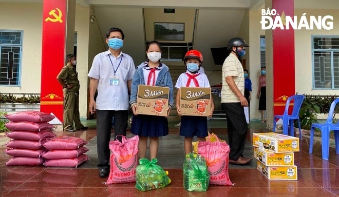 Ban giám hiệu Trường tiểu học Phan Phu Tiên trao quà hỗ trợ cho học sinh. Ảnh: NGỌC ĐOAN
