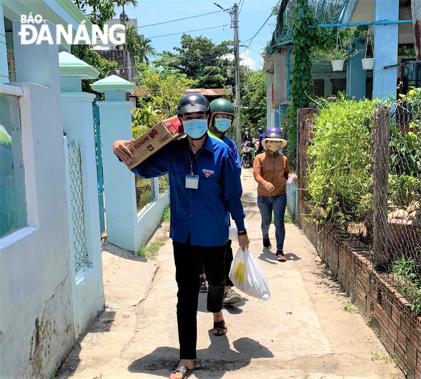 Không chỉ là “cửu vạn” áo xanh, các đoàn viên, thanh niên còn là người vận chuyển quà đến từng hộ dân. Trong ảnh: Đoàn Thanh niên xã Hoà Phước (huyện Hoà Vang) mang quà xuống từng thôn, xóm trao tận tay người dân. Ảnh: L.P