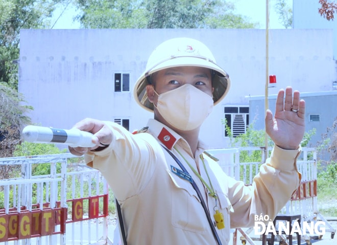 Dù nắng gắt hay mừa dâm, lực lượng Cảnh sát giao thông vẫn miệt mài bám chốt, quyết tâm ngăn chặn Covid-19 lây lan từ bên ngoài vào thành phố. Ảnh: NGỌC PHÚ