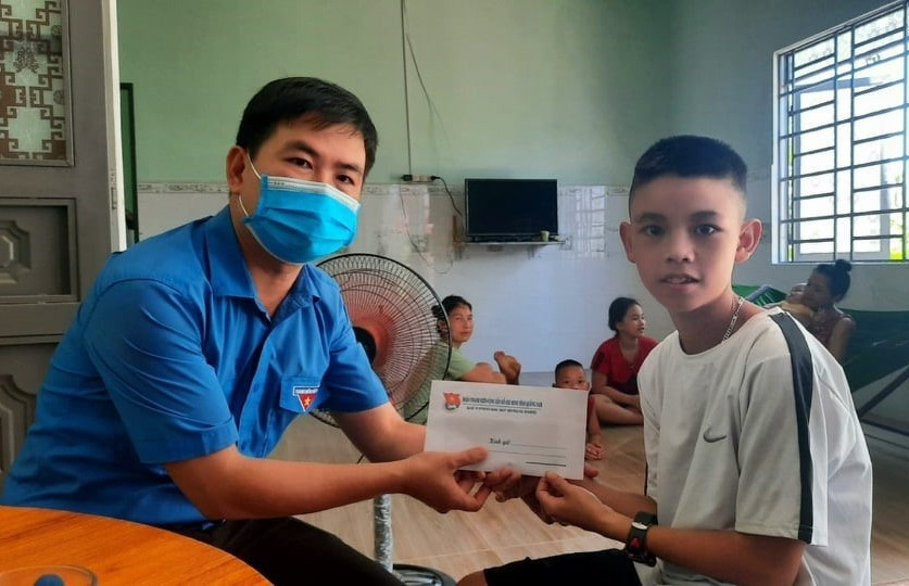 Anh Lê Quang Quỳnh trao học bổng 10 triệu đồng cho em Bùi Văn Chính - Ảnh: THANH VY - THÁI CƯỜNG