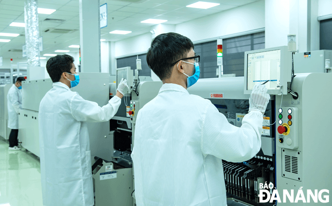 Các doanh nghiệp trên địa bàn thành phố rất nỗ lực để có thể duy trì sản xuất và phòng, chống dịch bệnh.  TRONG ẢNH: Kỹ sư vận hành Nhà máy nghiên cứu sản xuất thiết bị điện tử công nghệ cao SMT (Trungnam EMS) tại Khu Công nghệ cao Đà Nẵng. Ảnh: PHẠM ĐĂNG KHIÊM