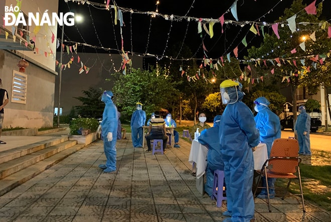 Lực lượng y tế quận Cẩm Lệ tiến hành lấy mẫu xét nghiệm cho toàn bộ người dân tại chung cư CT02, phường Hòa Thọ Đông tối 6-9. Ảnh: CTV