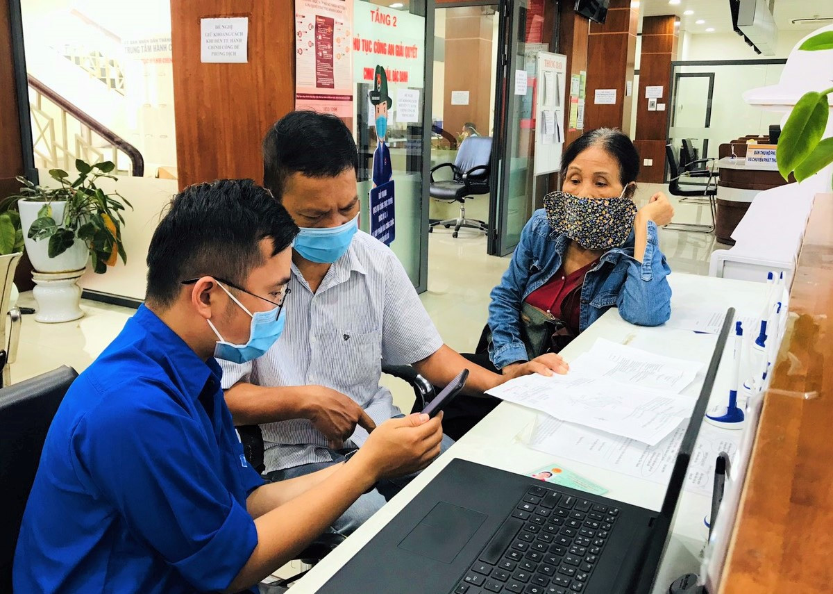 Đội Thanh niên xung kích của Thành đoàn Tam Kỳ tham gia hỗ trợ người dân nộp hồ sơ thủ tục hành chính trực tuyến tại Trung tâm Hành chính công thành phố. Ảnh: VINH ANH