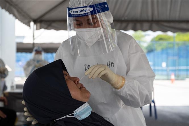 Nhân viên y tế lấy mẫu xét nghiệm COVID-19 cho người dân tại Kuala Lumpur, Malaysia . Ảnh: AFP/TTXVN