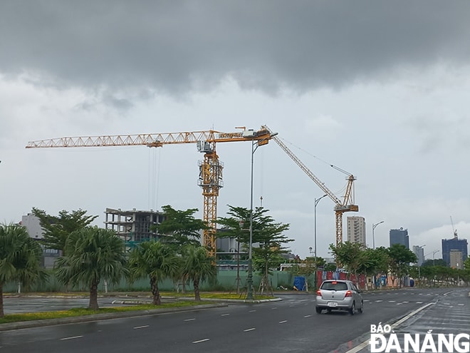 Các cần trục pháp xây dựng công trình cao tầng ven tuyến đường Bạch Đặng nối dài thực hiện hạ độ cao để chống ngã đỗ.