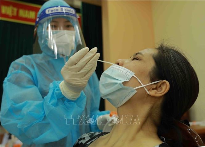 Lấy mẫu xét nghiệm sàng lọc SARS-CoV-2. Ảnh: TTXVN