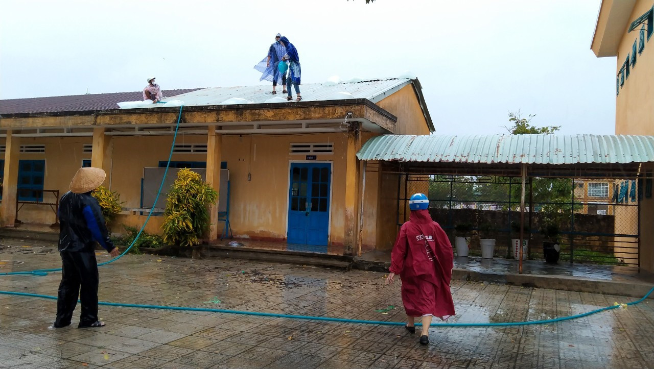 Người dân thực hiện gia cố mái nhà để hạn chế thiệt hại do bão số 5 gây ra. Ảnh: N.H.LAI