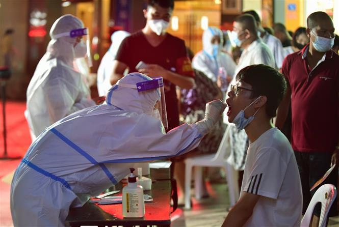 Nhân viên y tế lấy mẫu xét nghiệm COVID-19 cho trẻ em tại Phúc Kiến, Trung Quốc, ngày 12/9/2021. Ảnh: THX/ TTXVN