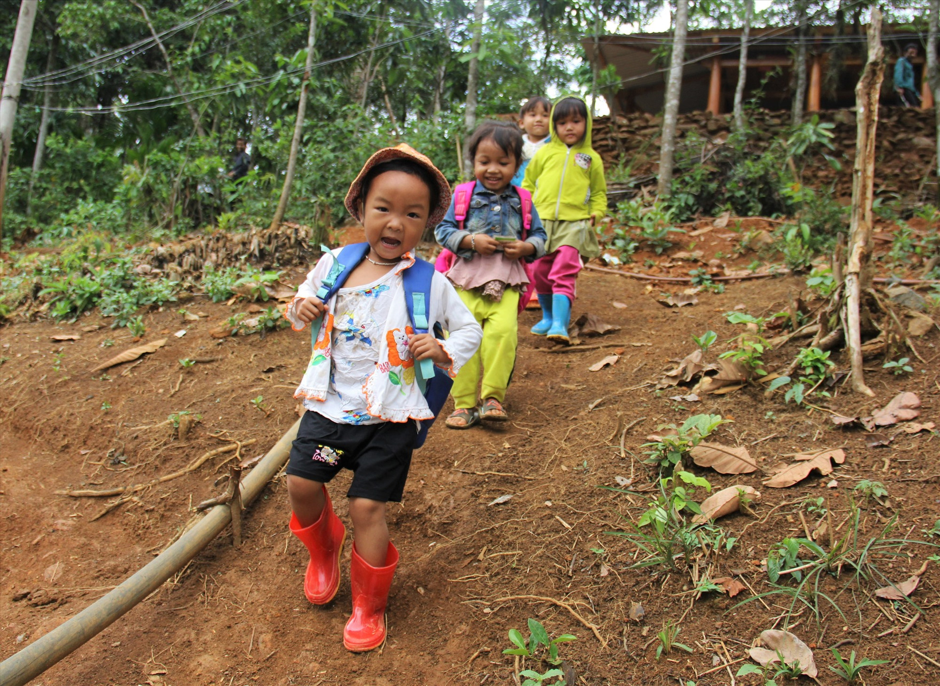 Các em nhỏ người Xê Đăng ở nóc Long Bok (thôn 3, xã Trà Mai, Nam Trà My) trên đường về nhà sau buổi học. Để đi đường an toàn, cha mẹ đã sắm ủng cho các em.