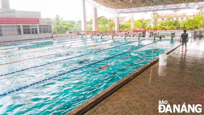 Các vận động viên đang nỗ lực tập luyện trong bể bơi chờ được nâng cấp. Ảnh: XUÂN SƠN