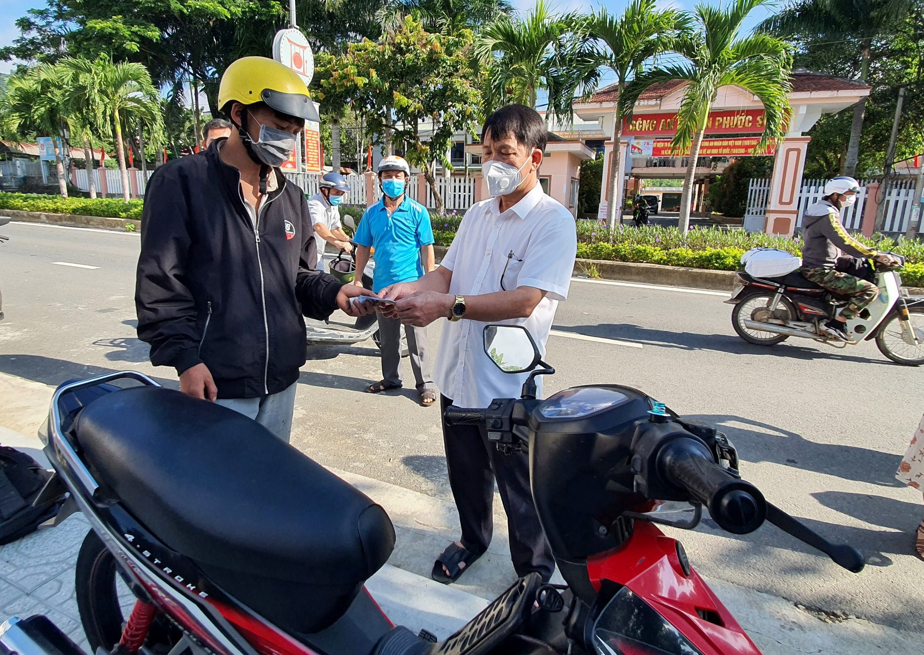 Ông Lý Minh Tám (áo trắng) tặng xe máy, cà vẹt xe cho Hạ Bá Tênh. Ảnh: T.C