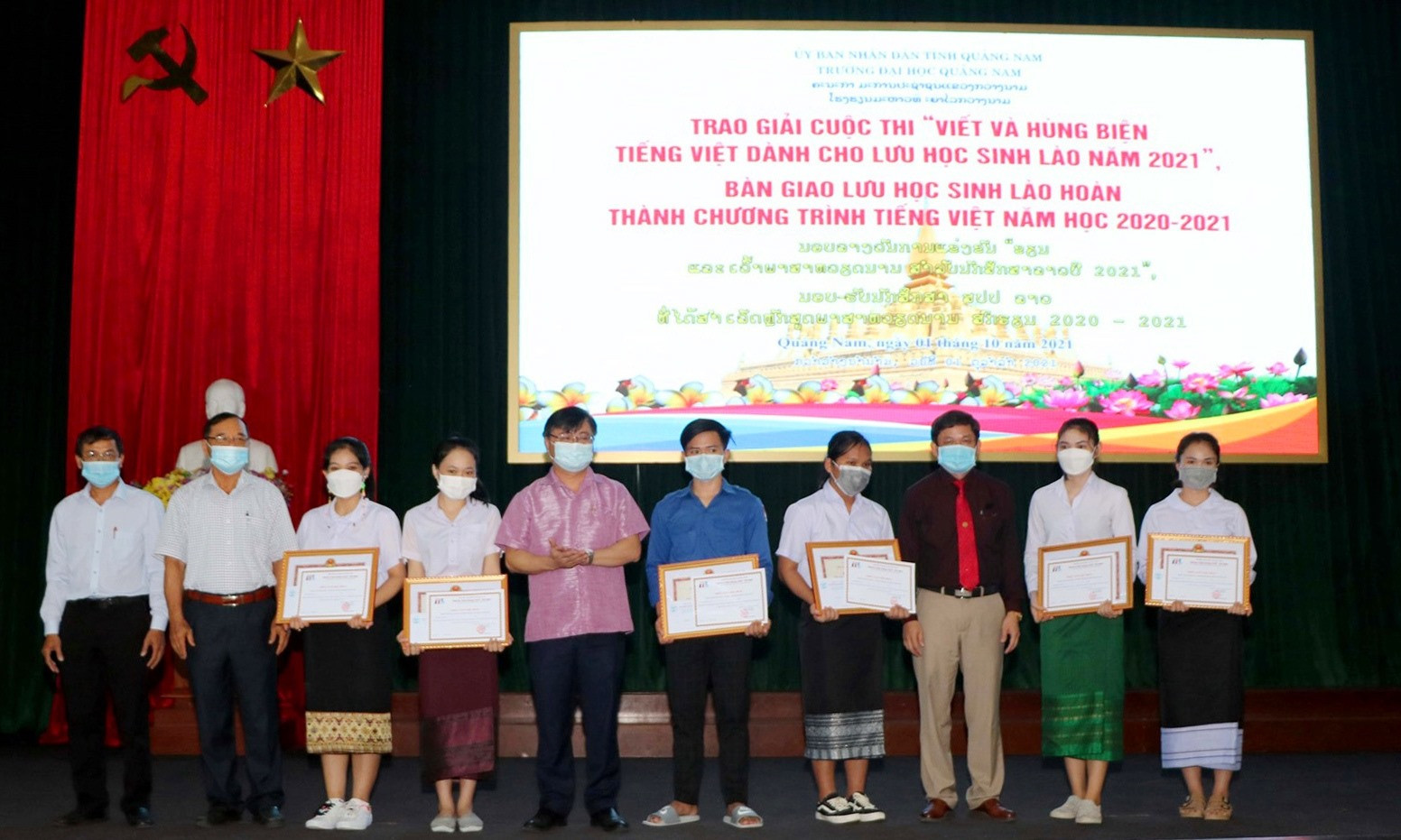 Trao thưởng cho các em đạt giải trong cuộc thi “Viết và hùng biện tiếng Việt dành cho lưu học sinh Lào”. Ảnh: CHÂU HÙNG