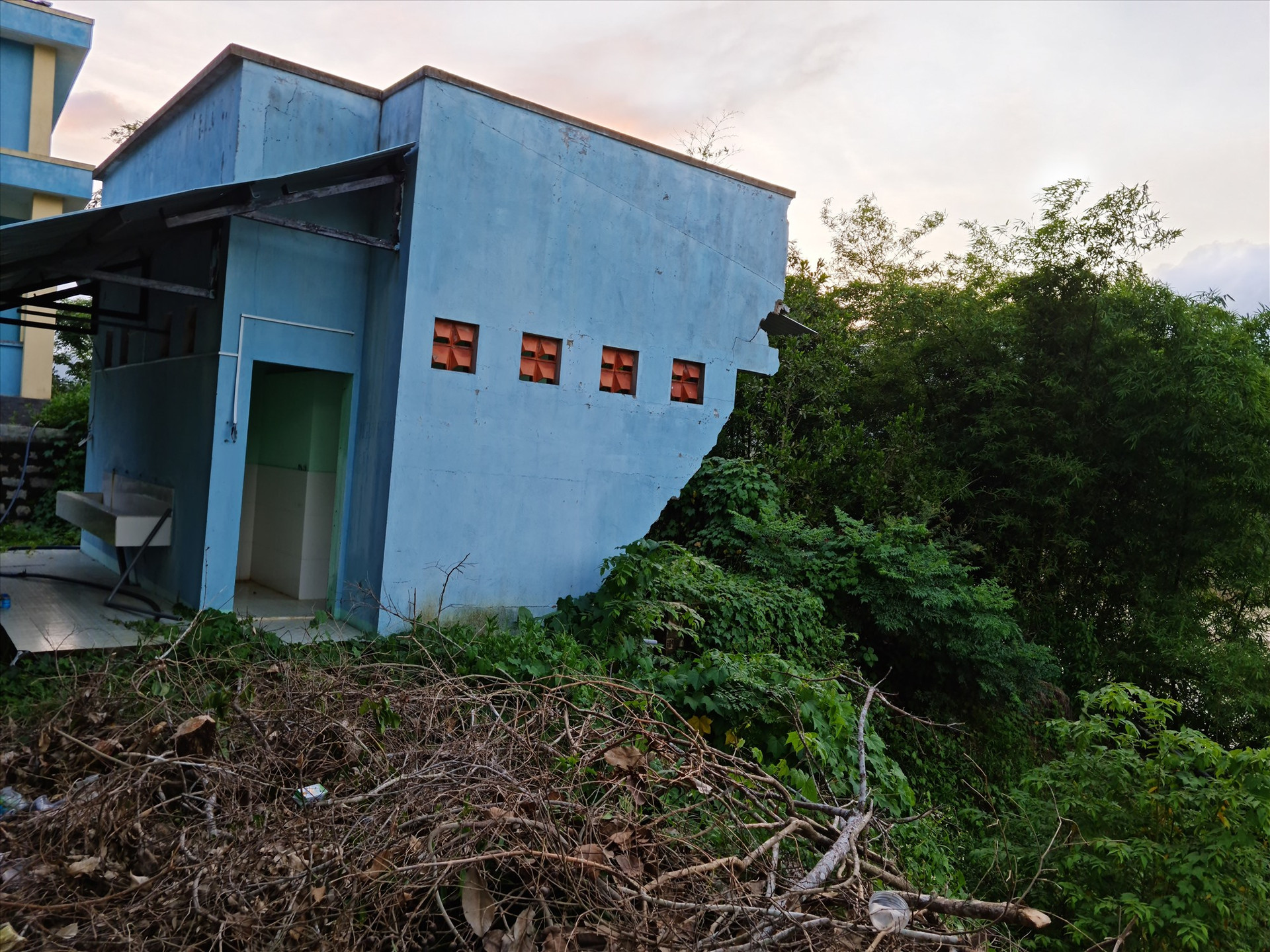 Khu nhà vệ sinh mới xây dựng thuộc trường cấp 2 của xã Quế Trung bị sụp đổ do sạt lở. Ảnh: H.L