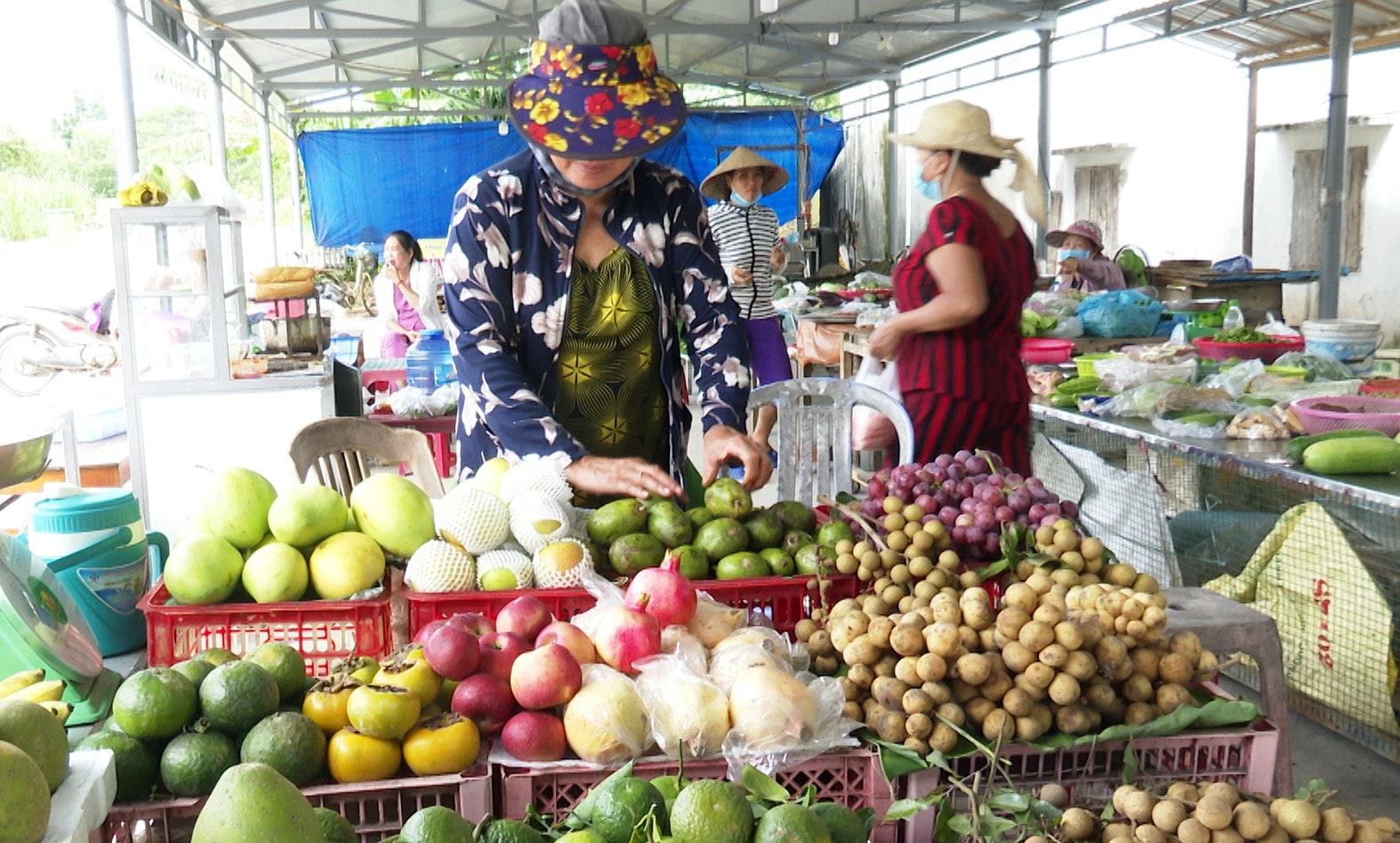 Bà Trần Thị Duyên sử dụng nguồn vốn vay từ Chương trình tài chính vi mô về mở quầy bán trái cây tại chợ xã. Ảnh: N.HƯNG