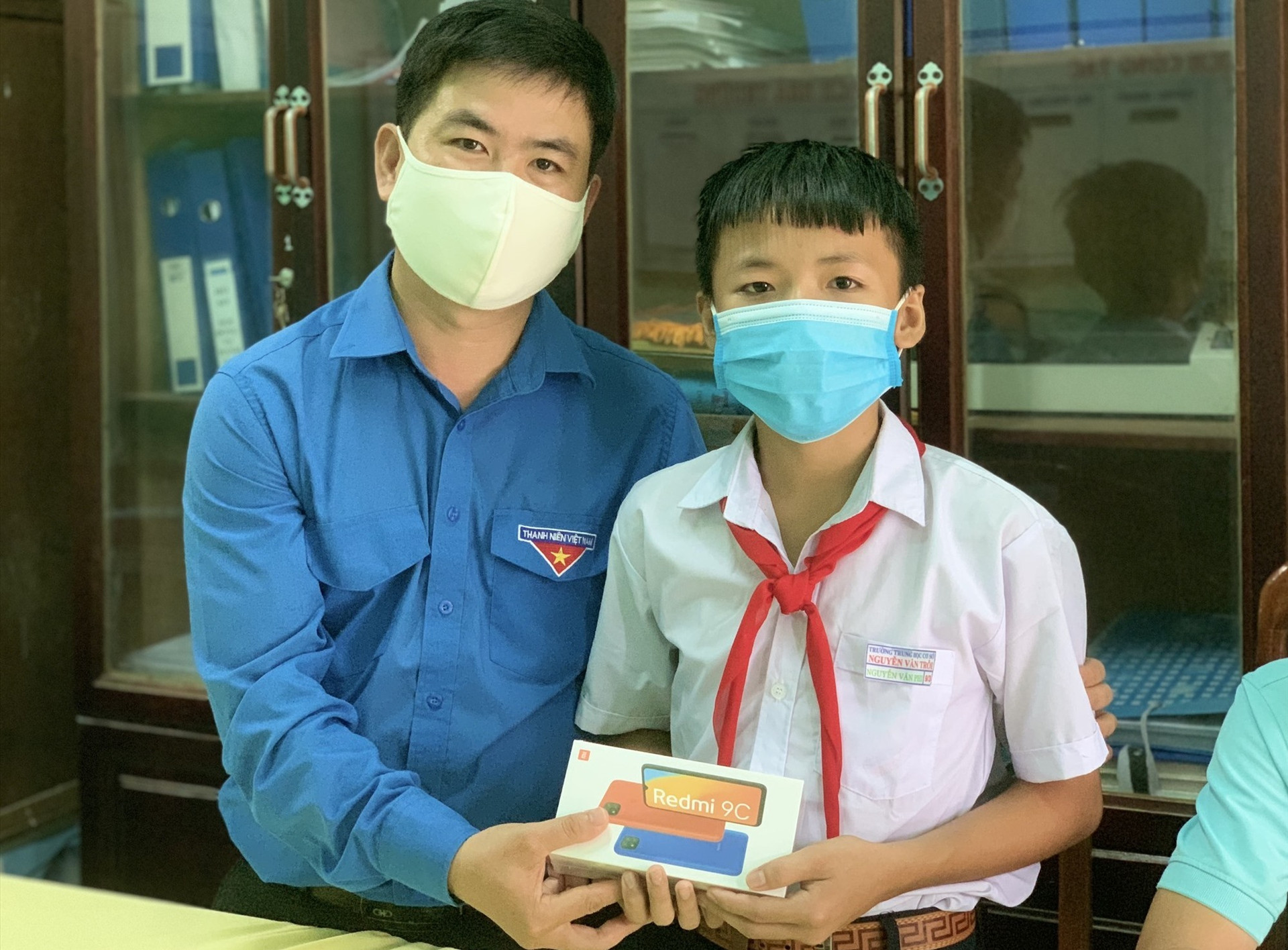 Chủ tịch Hội đồng Đội tỉnh Lê Quang Quỳnh tặng smartphone cho em Nguyễn Anh Phi. Ảnh: THU VUI