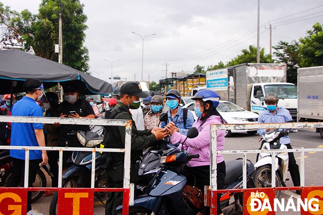 Lực lượng chức năng tại chốt C5 (Quốc lộ 1A, xã Hòa Phước, huyện Hòa Vang) kiểm tra giấy tờ cá nhân của người dân trước khi vao khu vực khai báo y tế. Ảnh: XUÂN DŨNG