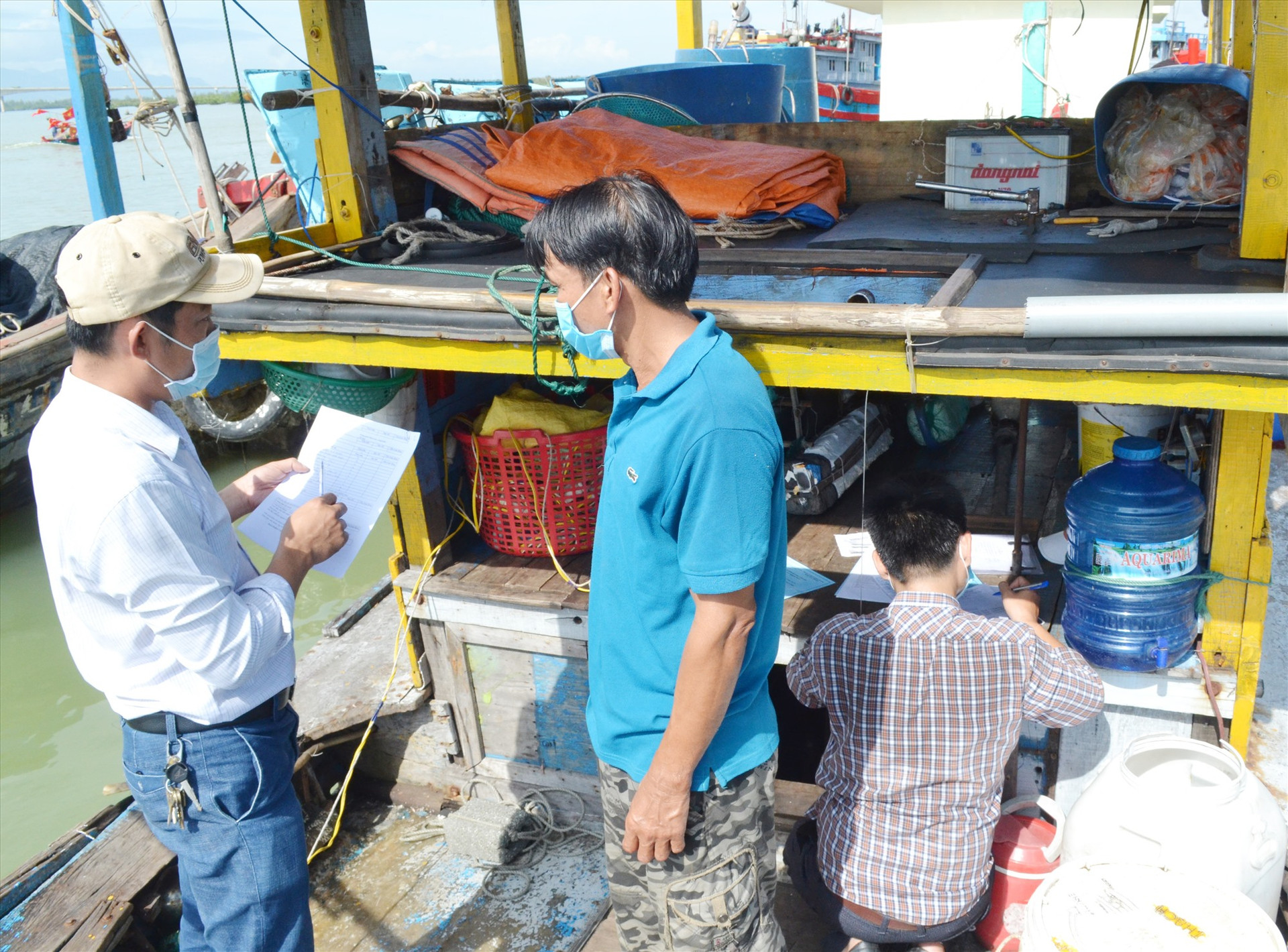 Các đăng kiểm viên thực hiện đăng kiểm trên tàu cá của ngư dân huyện Núi Thành. Ảnh: VIỆT NGUYỄN