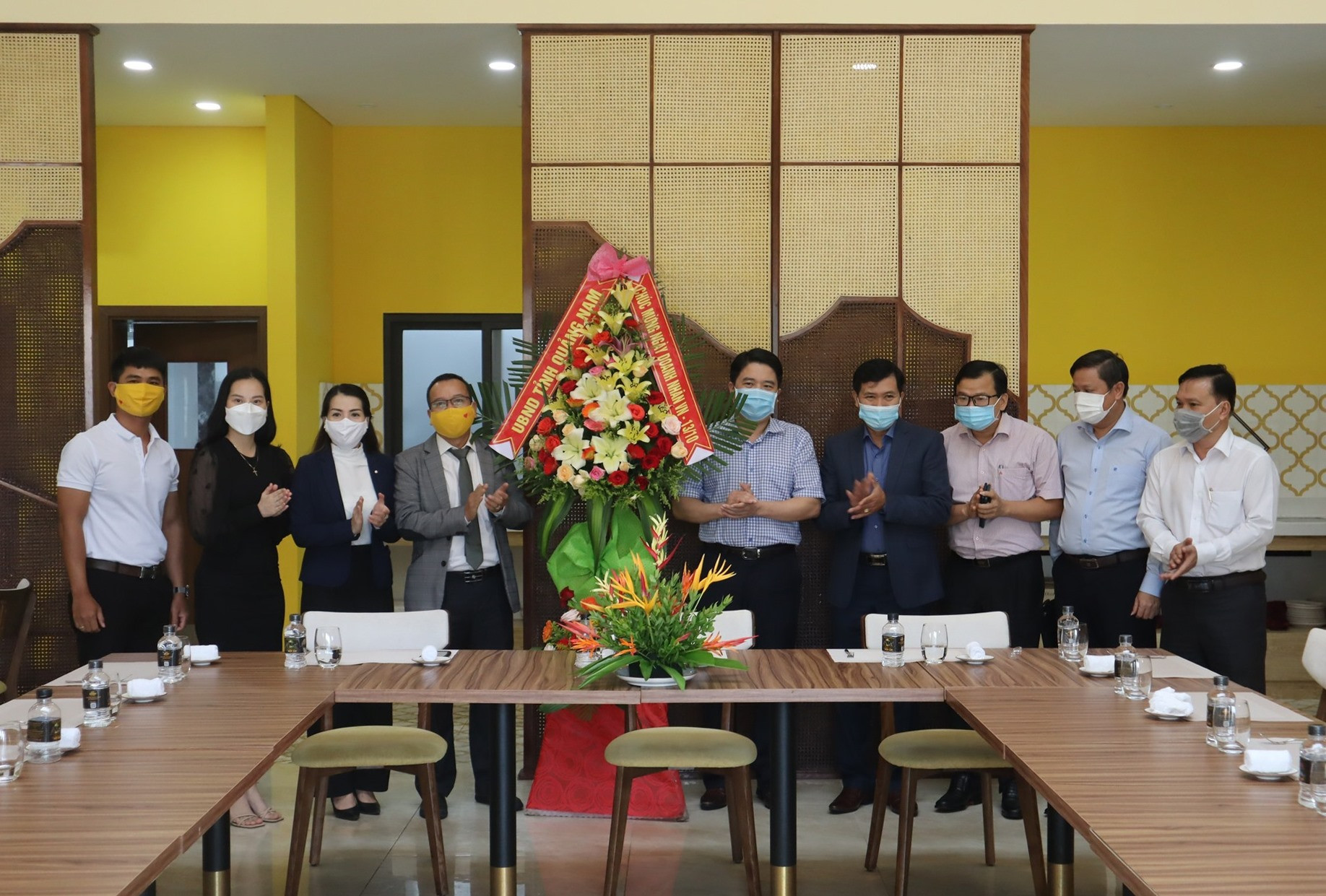 Lãnh đạo tỉnh tặng hoa mừng Ngày Doanh nhân Việt Nam cho đại diện quản lý Công viên Ký ức Hội An. Ảnh: Q.T