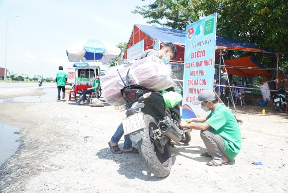 Lực lượng tình nguyện viên thay nhớt miễn phí cho xe máy của người dân. Ảnh: CTV