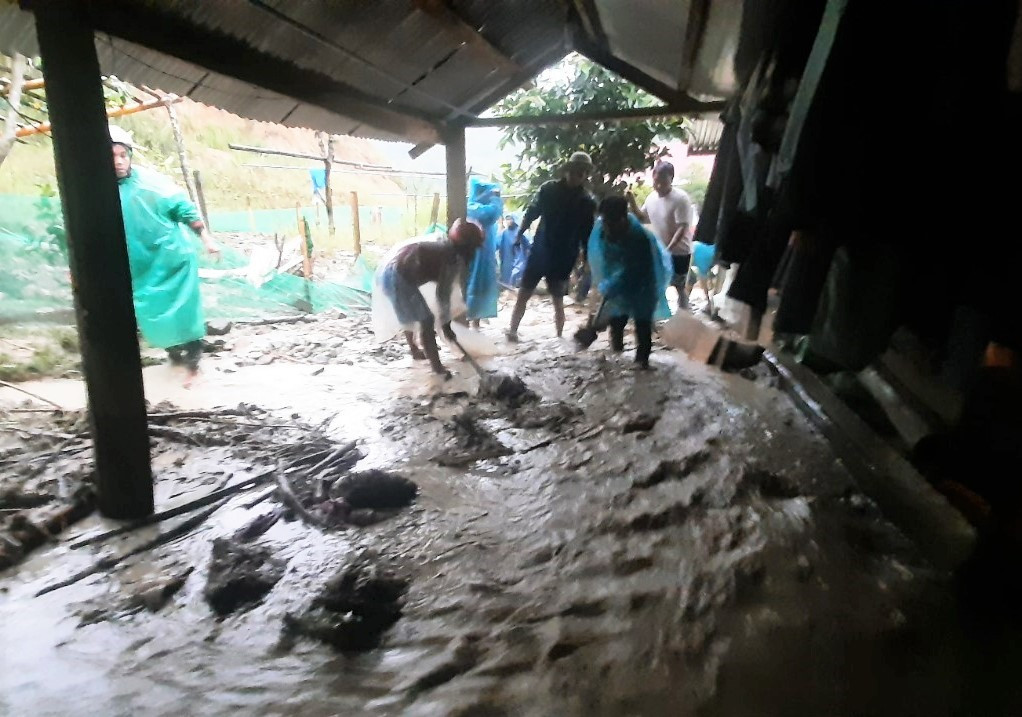 Người dân địa phương tham gia hỗ trợ nạo vét bùn đất do nước lũ tràn vào nhà dân. Ảnh: CTV