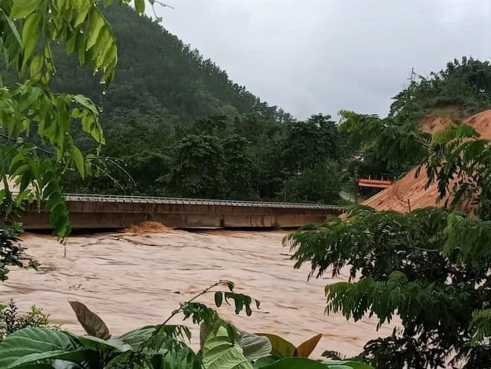 Mực nước lũ trên sông A Vương mấp mé cây cầu bê tông đi qua địa bàn xã A Rooih (Đông Giang). Ảnh: HỒ MINH