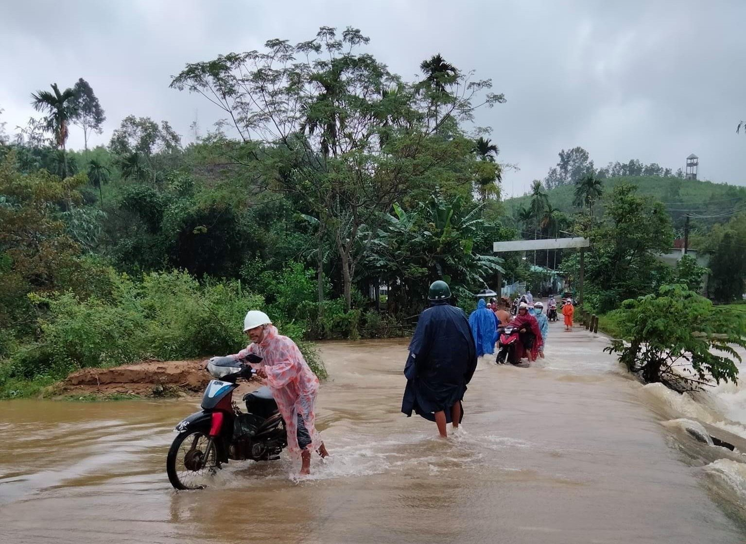 Người dân thôn 1 xã Trà Giang đi qua ngầm suối Nứa rất nguy hiểm do nước lũ băng qua.