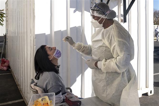 Nhân viên y tế lấy mẫu xét nghiệm Covid-19 cho người dân tại Johannesburg, Nam Phi. Ảnh: AFP/TTXVN