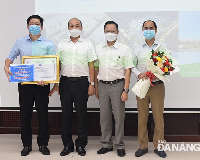 Phó Chủ tịch UBND thành phố Lê Quang Nam và Bí thư Quận ủy Hải Châu Vũ Quang Hùng trao thưởng cho Viện Quy hoạch xây dựng Đà Nẵng là đơn vị đoạt giải Nhất. Ảnh: TRIỆU TÙNG