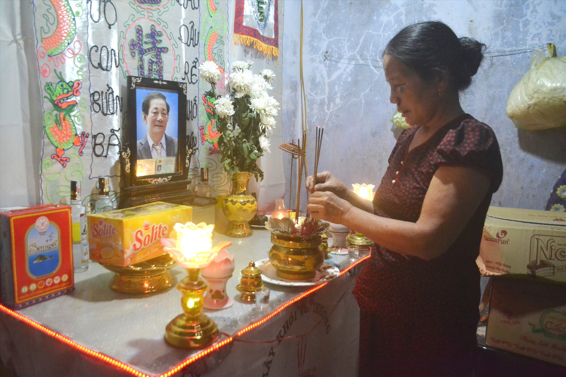 Người vợ đứng trước di ảnh của chồng bị tử vong do TNGT ở thôn Phước Đức, xã Quế Châu (Quế Sơn).