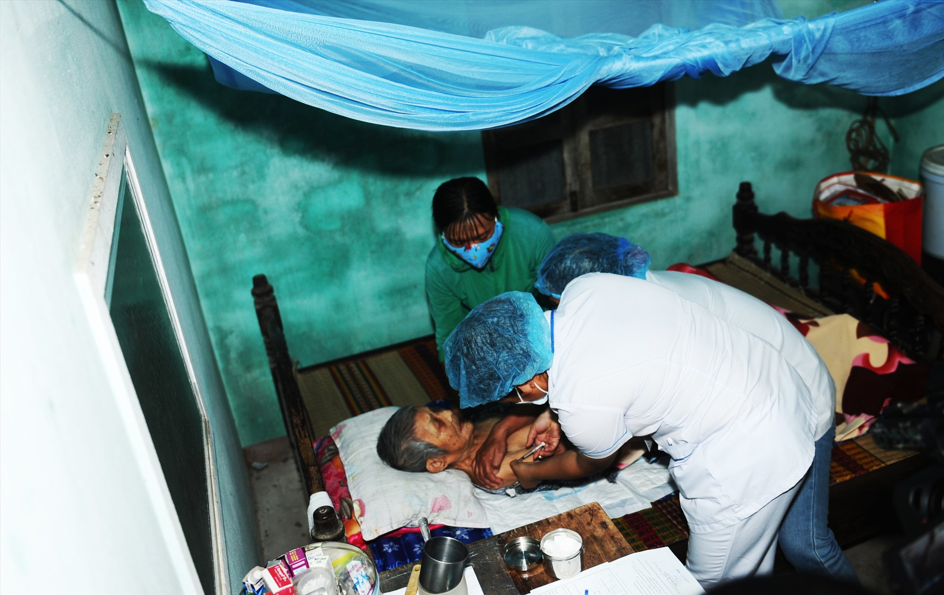 Cán bộ y tế tiêm ngừa vắc xin cho Mẹ VNAH Trần Thị Thùy ở xã Cẩm Thanh. Ảnh: MINH QUÂN