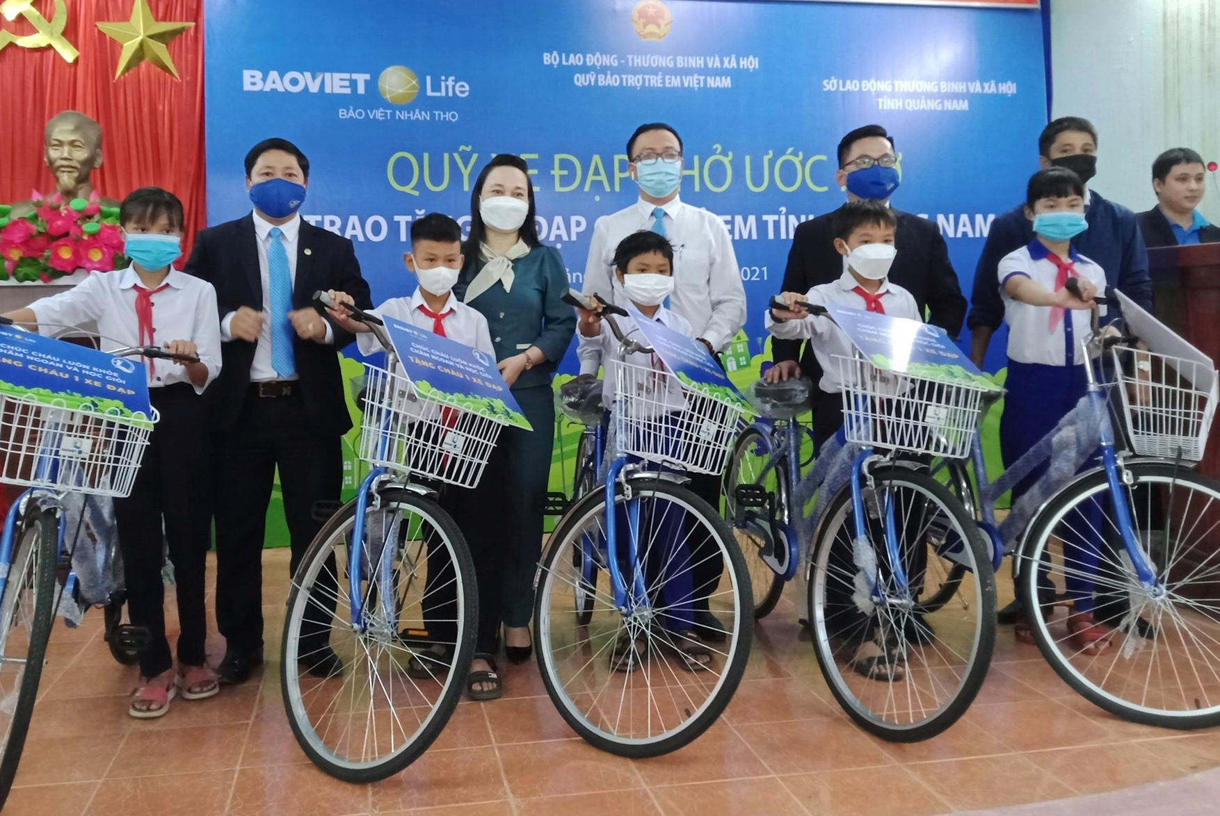Đại diện Công ty Bảo Việt và Sở LĐTB&XH tỉnh trao xe đạp cho học sinh Hiệp Đức. Ảnh: V.MINH