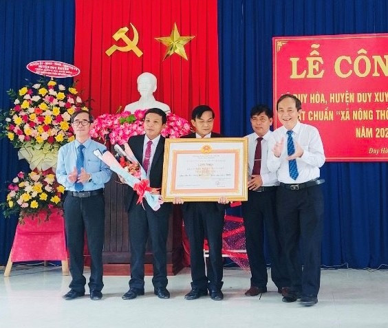 Lãnh đạo huyện Duy Xuyên trao bằng công nhận đạt chuẩn NTM nâng cao cho xã Duy Hòa.   Ảnh: T.N
