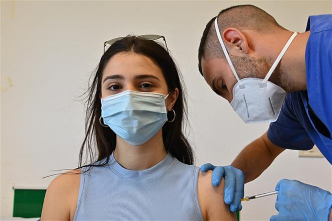 Nhân viên y tế tiêm vaccine ngừa Covid-19 cho người dân tại đảo Lampedusa, Italy ngày 15-5-2021. Ảnh: AFP/TTXVN
