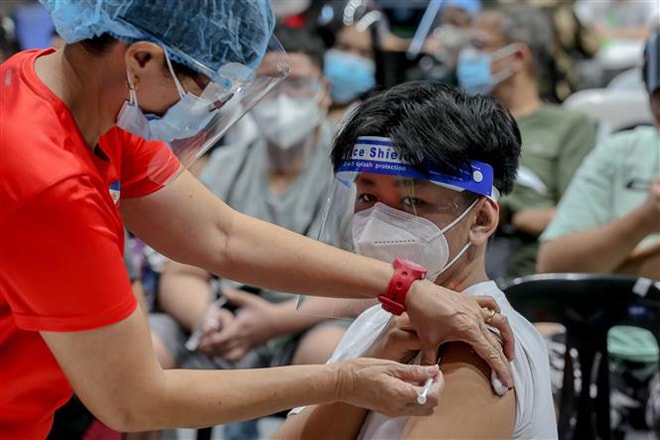 Nhân viên y tế tiêm vaccine phòng Covid-19 cho học sinh tại San Juan, Philippines, ngày 3-11-2021. Ảnh: THX/ TTXVN