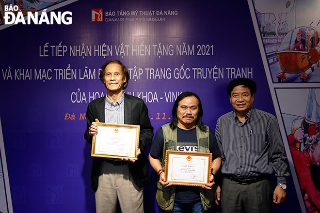 Phó Giám đốc Sở Văn hóa và Thể thao thành phố Hà Vỹ (bìa phải) tặng kỷ niệm chương cho các họa sĩ hiến tặng hiện vật năm 2021. Ảnh: XUÂN DŨNG