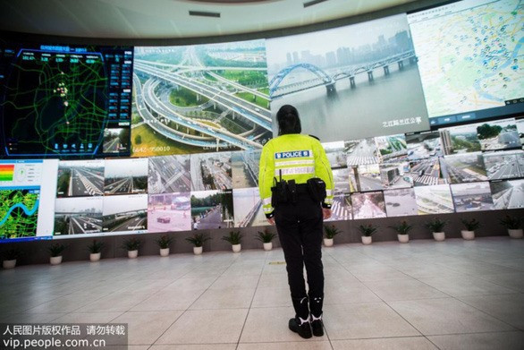 Một cảnh sát giao thông thành phố Hàng Châu (Trung Quốc) quan sát hiện trạng giao thông qua hệ thống công nghệ thông minh. Ảnh: people.com.vn